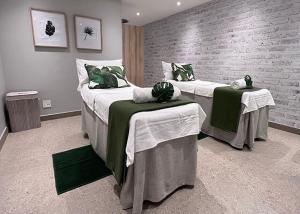 a bedroom with two beds with tables and a brick wall at 1 Bed Crystal Lagoon Escape in Pretoria