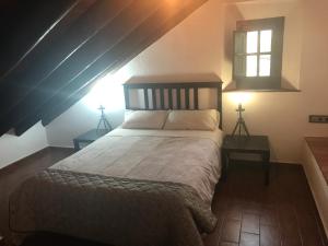 ein Schlafzimmer mit einem Bett mit zwei Tischen und einem Fenster in der Unterkunft Casa Cortijo in La Luisiana