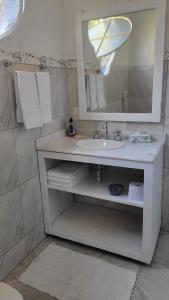 ein Badezimmer mit Waschbecken, Spiegel und Handtüchern in der Unterkunft Suítes da Rua Belica in Tiradentes + 19 Fotos