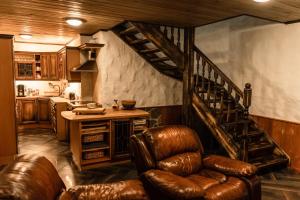 a kitchen with a spiral staircase and leather chairs at Krapi Guesthouse in Treimani