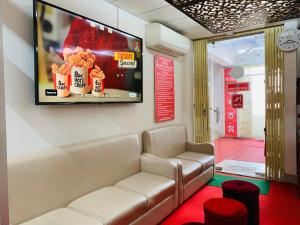 a waiting room with a couch and a tv on the wall at Hotel Rose Garden Palace Residential in Dhaka