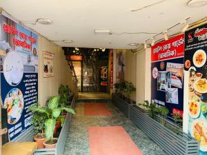 a store hallway with plants and signs on the walls at Hotel Rose Garden Palace Residential in Dhaka