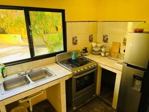 a kitchen with a stove and a sink and a window at Bungalows Las Palmas Cabo Pulmo in Cabo Pulmo +18 photos