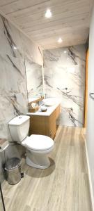 a bathroom with a toilet and a sink at The Zephyr House in Pyrgos