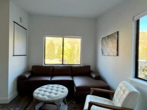 a living room with a leather couch and a table at Eagles Nest Cozy Retreat Mtn Views in Vail