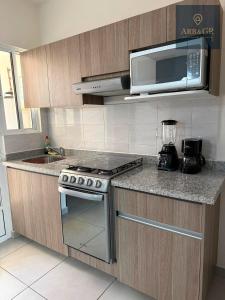 eine Küche mit Herd und Mikrowelle in der Unterkunft Casa de la laguna azul in Veracruz