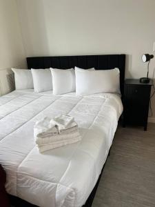 a large white bed with two towels on it at Red Velvet Studio in Des Moines