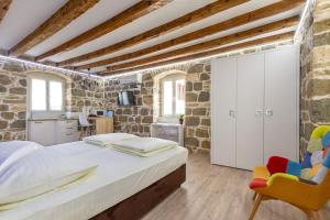 a bedroom with a large bed and a stone wall at Studio Central in Split