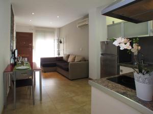 cocina y sala de estar con sofá y mesa en Apartamentos Amanecer JC1 en Murcia