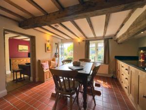a kitchen with a table and chairs in a room at Smith Yard Cottage, Ashbourne in Ashbourne