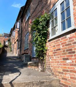 a brick building with a window and a plant at Smith Yard Cottage, Ashbourne in Ashbourne