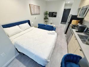 a large white bed in a room with a kitchen at Azure Oasis Studio in Des Moines