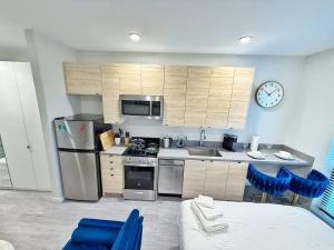 a kitchen with stainless steel appliances and a clock on the wall at Azure Oasis Studio in Des Moines +19 photos