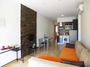 sala de estar con sofá y cocina en Apartamentos Amanecer JC1, en Murcia