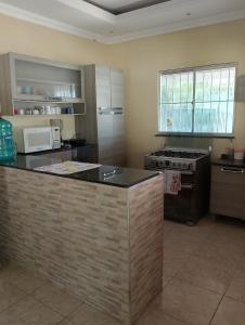 a kitchen with a stove and a counter top at Refugio Kitesurf - ilha do Guajirú in Itarema