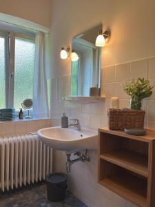 a bathroom with a sink and a mirror and a radiator at Maiergschwendter-Hof inkl. Chiemgaukarte in Ruhpolding +25 photos