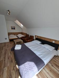 a bedroom with a large bed and a chair at Giecowka in Polańczyk
