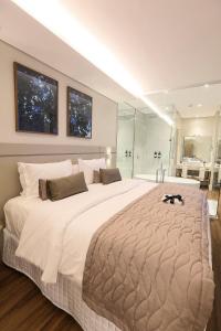 a large bedroom with a large bed and a bathroom at Hotel 4WOO in Telêmaco Borba