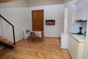 Una cocina con una mesa y sillas en una habitación. en Daisy Hotel Kutaisi, en Kutaisi