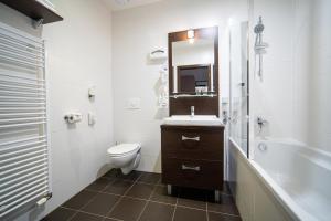 a bathroom with a sink and a toilet and a tub at Hotel Panorama in Štrbské Pleso