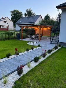 a patio with a table and chairs in a yard at Apartamenty nad Starynką in Głuchołazy