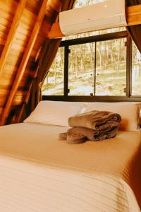 a bed in a room with a window at Cabana com banheira in Gramado