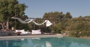 a swimming pool with a hammock and a table and chairs at Dimora Casanoja in Noci