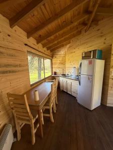 a kitchen with a table and a refrigerator in a cabin at Sweet Home 2 in Tigre