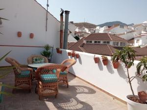 a patio with a table and chairs on a balcony at Apartamentos Virgen de Villaverde in Ardales