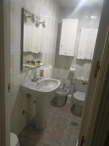 a white bathroom with a sink and a toilet at Hostal Villa María in La Nava de Ricomalillo +9 photos