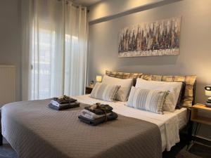 Un dormitorio con una cama grande con dos toallas encima. en Wait Fresh and New, en Tesalónica