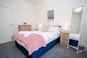 a bedroom with a large bed and two night stands at Vacant Nests The Fredrick Close To Sea Front in Seaham
