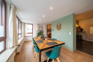 a dining room with a wooden table and blue chairs at Urban & Chic: 2Bdr, Parkplatz in Witten