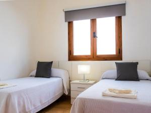 zwei Betten in einem Zimmer mit zwei Fenstern in der Unterkunft Live Caletillas Taunus pool in Punta Larga