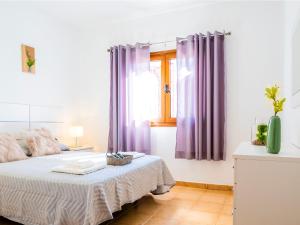 Schlafzimmer mit violetten Vorhängen und einem Bett in der Unterkunft Live Caletillas Taunus pool in Punta Larga