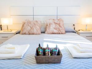 ein Bett mit zwei Handtüchern und einem Korb mit Zahnbürsten in der Unterkunft Live Caletillas Taunus pool in Punta Larga