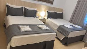 a hotel room with two beds and a window at Le Privilège Mont Blanc in Ribeirão Preto