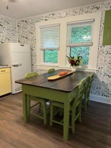a kitchen with a green table with chairs and a refrigerator at The Renovated Farmhouse at Seneca Rocks in Seneca Rocks +21 photos