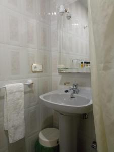 Un baño con lavabo, inodoro y espejo. en Hostal Villa María, en La Nava de Ricomalillo