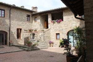 a stone building with stairs and flowers on it at Country Home Tuscany - Courtyard Room in Lano
