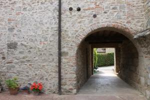 an archway in a brick wall with potted plants at Country Home Tuscany - Courtyard Room in Lano