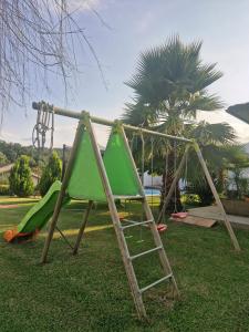 a playground with a green slide and a ladder at Logement indépendant avec piscine privée in Penta-di-Casinca