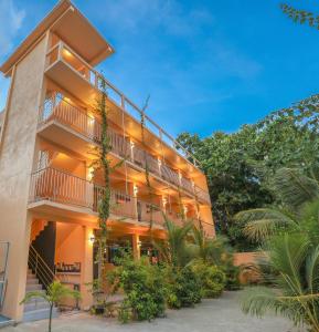 an apartment building with a balcony and plants at Relax Lodge in Thoddoo