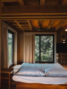 a bed in a bedroom with a large window at Loft kineki 6 in Puerto Escondido