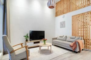 a living room with a couch and a tv at Nordic Wooden House in Rovaniemi