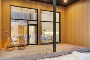 a patio with two chairs and a table and windows at Nordic Wooden House in Rovaniemi