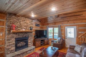 a living room with a stone fireplace and a television at Adventure Cabin! Fire Pit, State Park, Fishing, Mtn Views, Hot Tub, WiFi in Jefferson