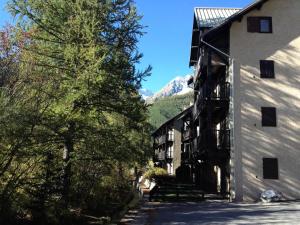 a view of a building with a mountain in the background at Résidence Gardiole 4 - Appartement spacieux · Proche des pistes · Wifi gratuit & proche des Grands Bains MAE-0234 in Le Monêtier-les-Bains