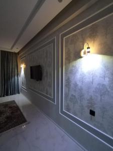 a room with a wall with a painting of trees on it at Abşeron City yaşayış kompleksi in Sumqayyt