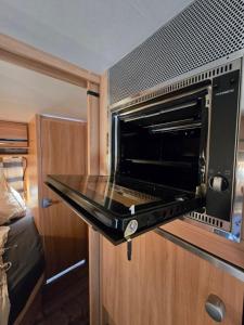 Un horno tostador en un armario en una casa rodante. en Rosenzauber Caravan, en Mussen